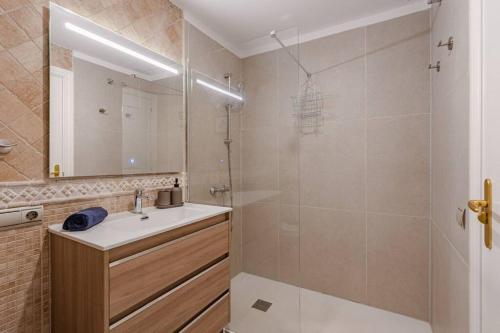 a bathroom with a sink and a shower with a mirror at Seaside Apartment with Spacious Terrace, Pool, and Wi-Fi in Santa Cruz de Tenerife