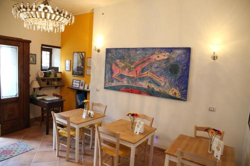 un comedor con mesas y una pintura en la pared en Le Stanze dei Nonni, en Avellino