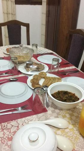 a table with plates and bowls of food on it at SULKHAN SERVICED APARTMENT in Chukwani