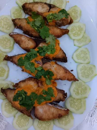 a plate of food with meat and vegetables on it at SULKHAN SERVICED APARTMENT in Chukwani