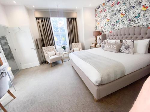 a bedroom with a large bed and a chair at The Orchid Hotel in Bournemouth