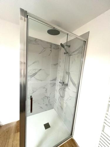 une douche avec une porte vitrée dans une salle de bain dans l'établissement Location T2 44 m2 proche plage Lecci appartement 82, à Lecci