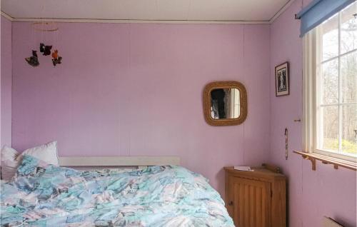 a bedroom with purple walls and a bed and a mirror at Lovely Home In Kallinge in Kallinge