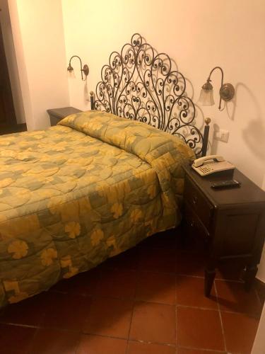 a bedroom with a bed and a table with a phone at Hotel Bucaneve in Pescasseroli