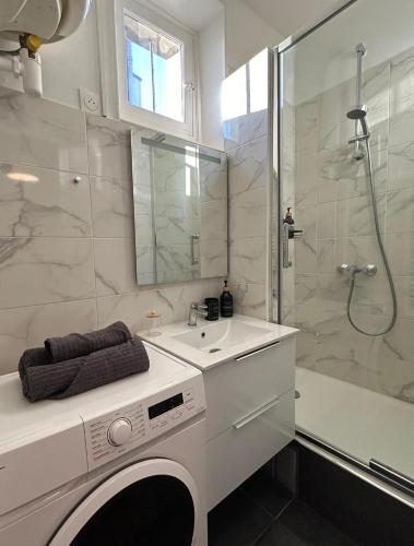 une salle de bain blanche avec un lavabo et une douche dans l'établissement Charmant 2 pièces à deux pas de Paris, à Saint-Maurice