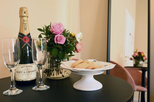 a table with a bottle of champagne and a plate of cookies at Ta-49 bed e breakfast in Naples