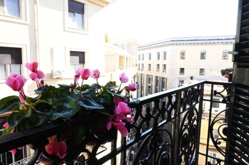 a planter with pink flowers sitting on a balcony at Ta-49 bed e breakfast in Naples