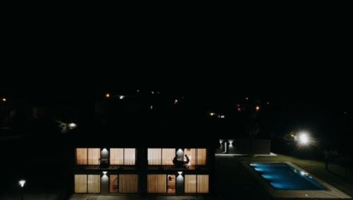 a building at night with a pool in front of it at Dalpendre - Turismo em espaço rural in Felgueiras