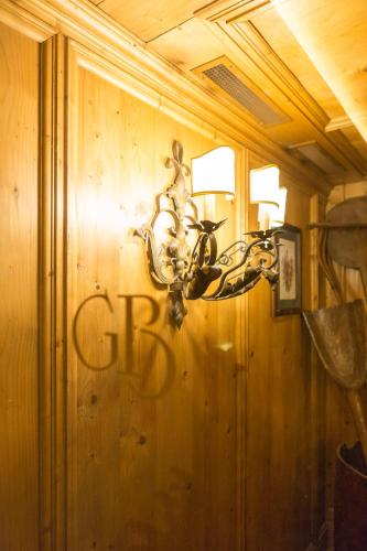 a light on a wooden wall with graffiti on it at Gran Baita Hotel & Wellness in Courmayeur