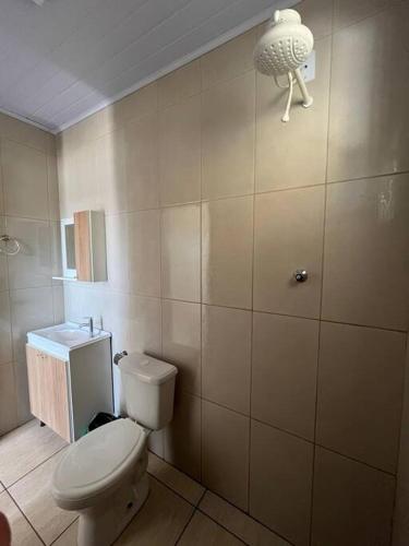 a bathroom with a toilet and a light on the wall at casa nova em imbé in Imbé