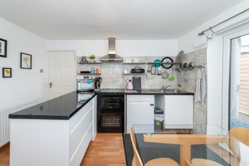 a kitchen with a black counter top and a table at Family home, view of Windsor Castle in Dorney