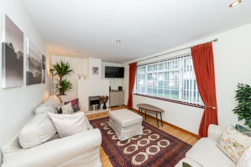 a living room with white furniture and a large window at Family home, view of Windsor Castle in Dorney