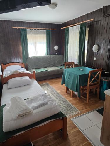 a bedroom with a bed and a table and a room at Studios Šumska Kuća 1 in Kopaonik