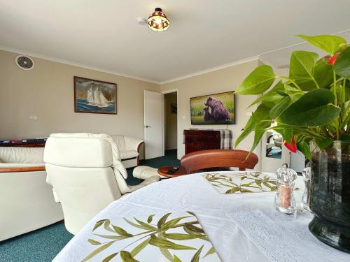 a living room with a table and a couch and a chair at Kings Corner - 5min to CBD & 20min to Airport in Sandy Bay