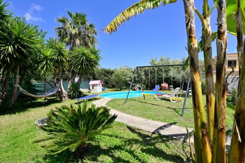 a backyard with a pool and a swing at Sa Omu Bianca in Tortolì
