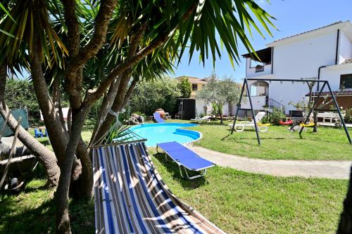 a backyard with a pool and a playground at Sa Omu Bianca in Tortolì