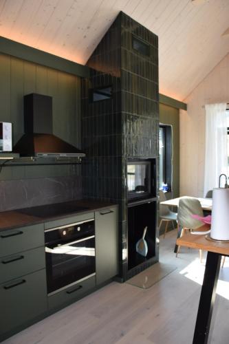 a kitchen with a black oven and a table at Ljungvind Funäsdalen in Funäsdalen