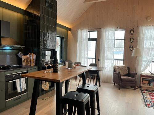 a kitchen with a table with stools and a dining room at Ljungvind Funäsdalen in Funäsdalen