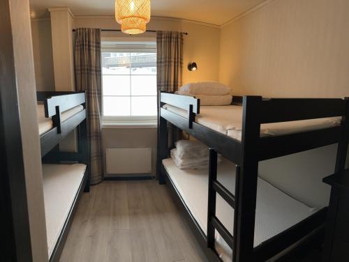 Habitación con 3 literas y ventana en Koselig leilighet på Gautefall, en Drangedal