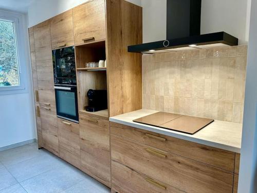a large kitchen with wooden cabinets and a stove at L'Élégance de Bellevue in Divonne-les-Bains