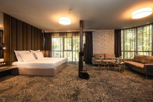 Un dormitorio con una cama y una sala de estar con un sofá. en Hotel Royal Plovdiv, en Plovdiv