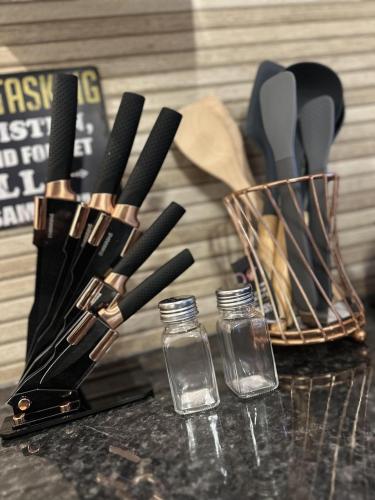 a group of knives and glass bottles on a counter at Renovated Studio - Free Parking - Great Location in Leeds