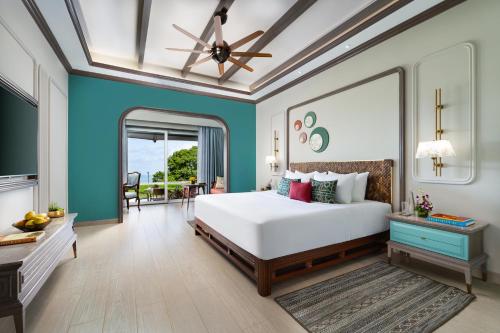 a bedroom with a white bed and blue walls at Fountain, Mahabaleshwar - IHCL SeleQtions in Mahabaleshwar