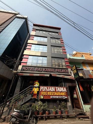Un edificio alto con un cartel delante. en Raj Kamal Hotel Near Temple With Lift, en Varanasi