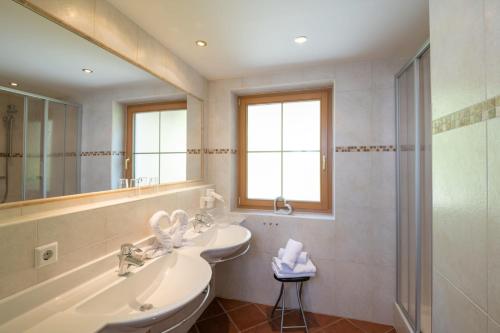 a bathroom with a sink and a mirror and a shower at Natur & Familienhotel Der Stieglerhof in Radstadt