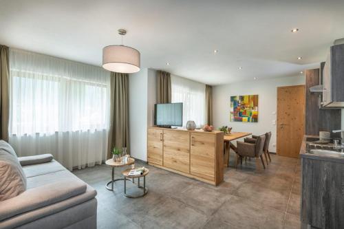 a living room with a couch and a table with a television at Natur & Familienhotel Der Stieglerhof in Radstadt