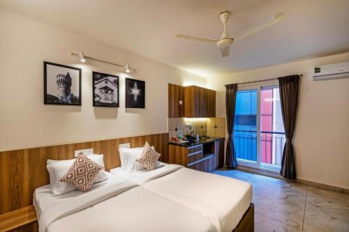 a bedroom with a large white bed and a bathroom at Wandr Hotel- Near MG Road in Bengaluru