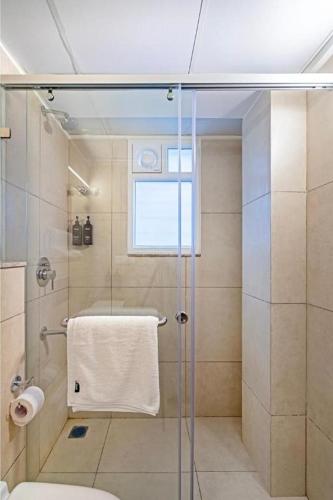 a bathroom with a shower with a glass door at Wandr Hotel- Near MG Road in Bengaluru