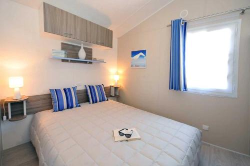 a bedroom with a large bed and a window at Camping 5 étoiles - Parc aquatique - eeiade in Brem-Sur-Mer