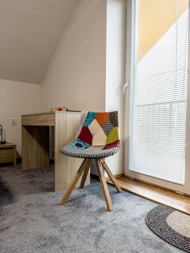 a chair with a pillow on it in a room at Penzión Tulipán in Jelka