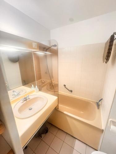 une salle de bain avec un lavabo et une baignoire dans l'établissement Studio idyllique et cosy à La Baule - Plage à pied, à La Baule