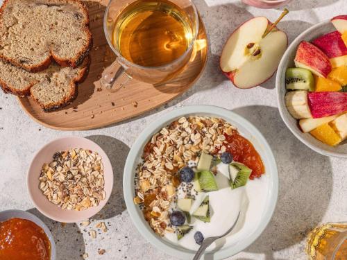 a table with a bowl of granola and a bowl of fruit at ibis Nürnberg Hauptbahnhof in Nürnberg