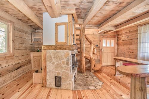 una baita di tronchi con soggiorno e camino in pietra di Lodge Nadgora a Žabljak