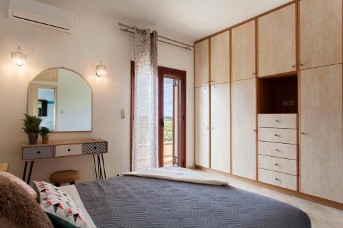 sypialnia z łóżkiem, komodą i lustrem w obiekcie GreenLand Villa w mieście Khoumérion