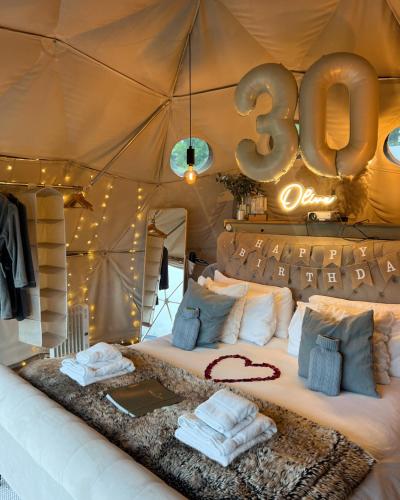 a room with a bed in a tent with at Beautiful Olive Pod Geo Dome House with Hot Tub in East Horsley