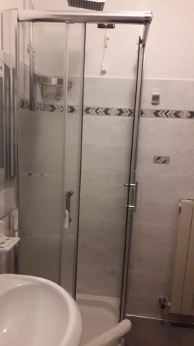 a shower with a glass door next to a sink at Hotel Bucaneve in Pescasseroli