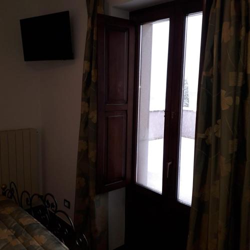 a window in a room with a bed and a curtain at Hotel Bucaneve in Pescasseroli