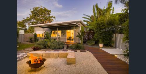 una casa con una hoguera en el patio delantero en Shoaly House and Shoaly House Cottage - perfect for multiple families & wedding groups, en Shoal Bay