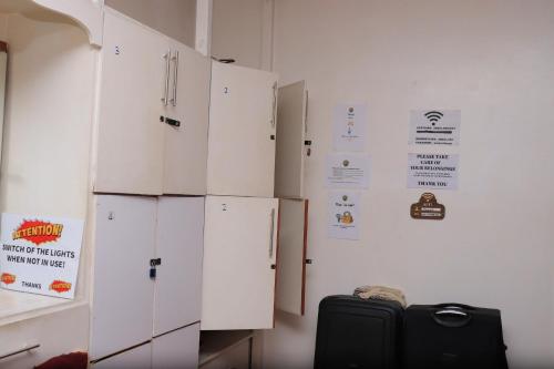 a room with white cabinets and a black suitcase at Jabulani Nairobi Backpackers Hostel in Nairobi