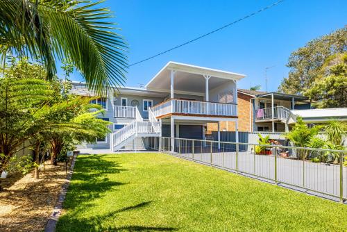 a house with a fence in front of a yard at Shoaly House and Shoaly House Cottage - perfect for multiple families & wedding groups in Shoal Bay