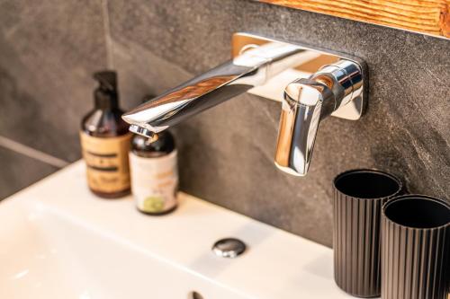 a bathroom sink with a bottle of wine on it at Chalet Hoamat Leben in Leogang