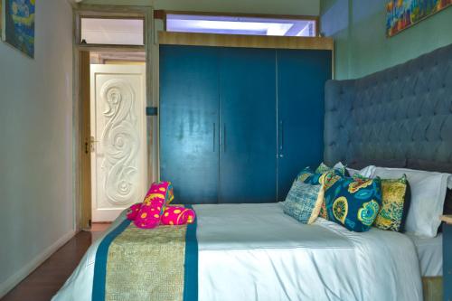 a bedroom with a bed with a blue wall at Boutique Villa on the Rocks with Stunning Sea Views, Infinity Pool & Private Sea in Trou dʼ Eau Douce