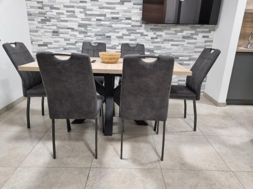 a dining room table with chairs and a bowl on it at Apartma Termal Čatež - nastanitev z vključenimi 6-imi kopalnimi kartami - 6 tickets included in Čatež ob Savi