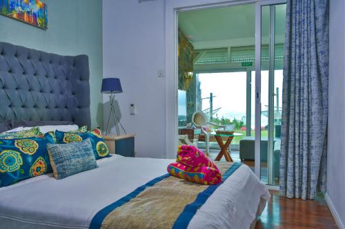 a bedroom with a bed with a large window at Boutique Villa on the Rocks with Stunning Sea Views, Infinity Pool & Private Sea in Trou dʼ Eau Douce