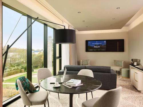 a living room with a table and a couch at Domaine du Liziec Vannes - MGallery Collection in Vannes