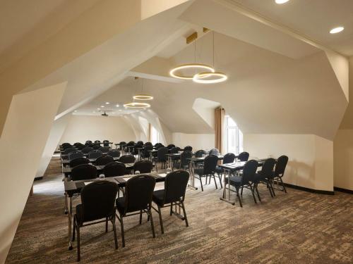 a large room with tables and chairs in it at Domaine du Liziec Vannes - MGallery Collection in Vannes